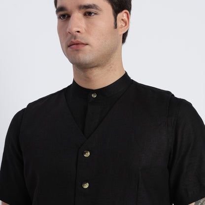 Man wearing a black shirt with buttons on a white background